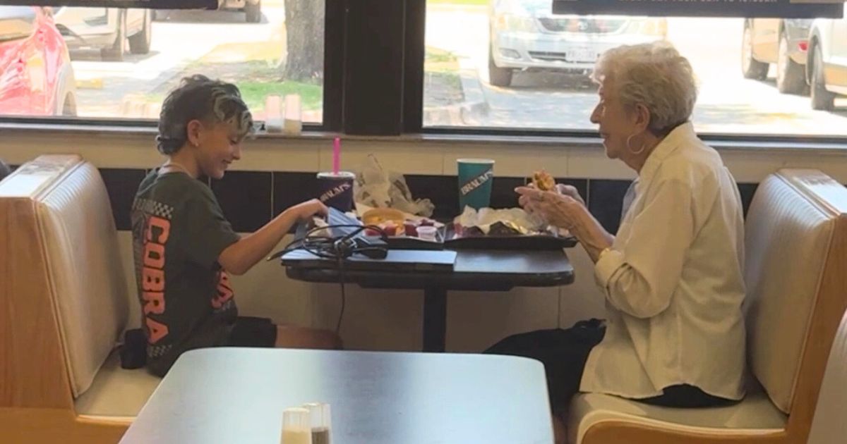 little boy dines with elderly woman