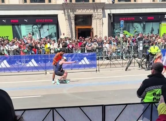 boston marathon runner helps another runner